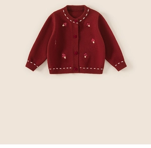 Detailed view of red knitted baby cardigan with white mushroom embroidery and round buttons