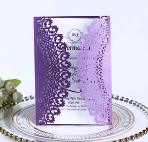 Detail of purple laser-cut wedding invitation with intricate floral patterns and card