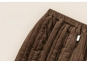 Detail of children's brown corduroy trousers showing elastic waistband and ribbed texture