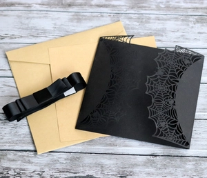 Laser-cut Halloween spider web invitation set with black card sleeve and kraft envelope