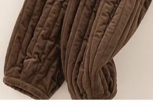Macro view of brown corduroy kids' trousers featuring elastic cuffs and thick ribbed texture