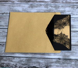 Detail of laser-cut spider web pattern on black Gothic Halloween invitation card