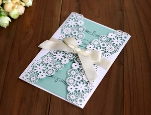 Détail de l'invitation de mariage découpée au laser avec carte menthe et ruban de soie