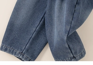 Detail of blue denim fabric with reinforced double stitching on children's warm jeans
