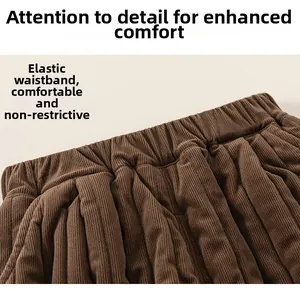 Detail of dark brown corduroy trousers showing elastic waistband and ribbed fabric texture