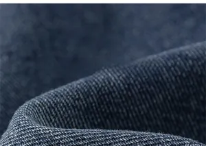 Detailed macro view showing premium thick denim twill texture and soft navy blue fabric fibers