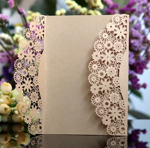 Gros plan de motifs floraux découpés au laser sur une invitation de mariage en kraft