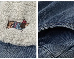 Detail view of cartoon dog embroidery on sherpa lining and denim pockets of kids pants