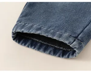Detail of kids deep blue denim pants with warm black fleece lining and loose cuff hem