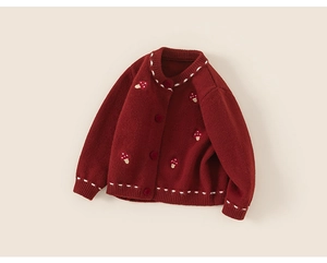 Detail of red knitted cardigan for kids featuring cute mushroom embroidery and white stitching