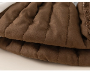 Close-up of dark brown quilted fabric showing vertical stitching and soft texture