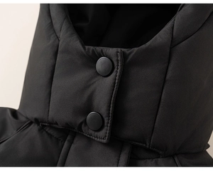 Detail shot of windproof collar with matte metal snaps on black quilted down jacket