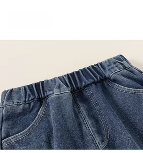 Detail of children's blue denim pants featuring a comfortable elastic waistband and stitching