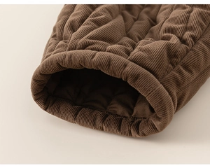 Close-up of brown corduroy quilted fabric showing sleeve cuffs and warm texture