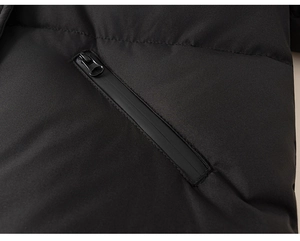 Detailed close-up of a child's black puffer jacket featuring a diagonal zipper pocket design