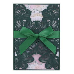Elegant emerald green laser-cut wedding invitation with satin bow and floral insert