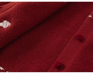 Close-up of deep red knitted cardigan featuring traditional Chinese knot buttons and mushroom embroidery