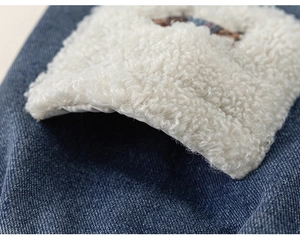Macro shot of dark blue denim fabric with white sherpa lining detail for winter pants