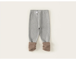 Detail view of baby knit leggings with contrasting brown ribbed cuffs and soft cotton texture