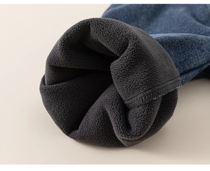 Detailed macro view of children's thick blue denim pants with warm grey fleece lining