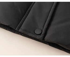 Detail shot of black quilted down jacket fabric with matte button and stitching