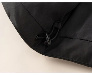 Detail of adjustable drawstring system on windproof black puffer jacket for kids