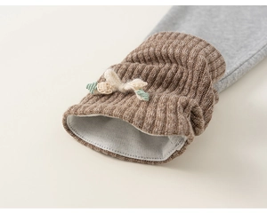 Detail of grey kid's leggings showing ribbed cuffs with crochet bow and leaf decoration