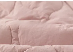 Close-up of pink quilted fabric showing fine stitching and warm padded texture of the pants