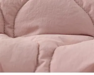 Detailed close-up of pink quilted fabric showing soft texture and wave stitching