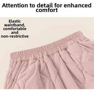 Detail of pink quilted kids pants showing the elastic waist and diamond stitching pattern