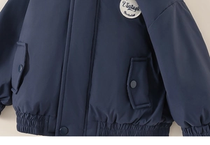 Detail of navy boy's jacket featuring vintage embroidery and windproof button flap pockets