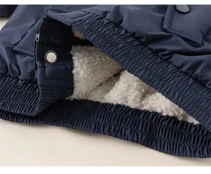Detail of boys' navy jacket showing elastic hem with warm white fleece lining