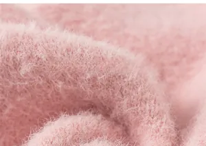 Close-up of soft pink fuzzy knit fabric showing plush texture and high-quality fibers