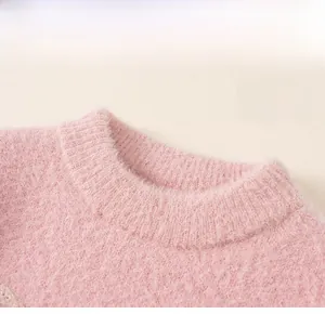 Close-up of the plush pink knit sweater showing soft mohair texture and ribbed crew neck