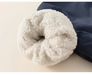 Detailed macro view of dark blue windproof fabric with thick white sherpa fleece lining