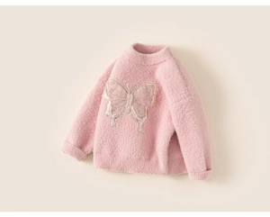 Close-up of pink knit girl sweater featuring sparkly sequined butterfly and mesh details