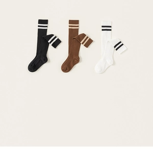 Detailed view of three pairs of ribbed cotton knee-high socks with athletic stripes