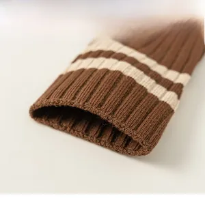 Detail of elastic ribbed cuffs on brown striped cotton knee-high socks for girls