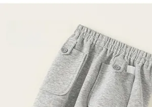 Détail de jogger en tricot gris avec taille élastique et grandes poches avec boutons
