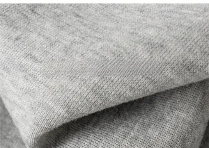 Gros plan du tissu en maille gris doux montrant la texture molletonnée pour pantalon enfant