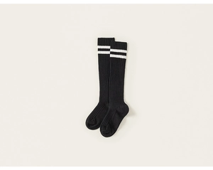 Detailed close-up of black knee-high cotton socks with white stripes and ribbed texture