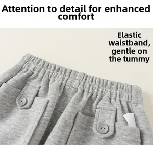 Détail d'un pantalon de jogging gris clair pour enfants avec taille élastique et boutons