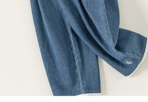 Dettaglio dei jeans da ragazza con bordo in pizzo bianco e ricamo floreale raffinato