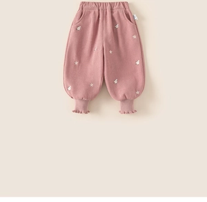 Detail of pink fleece pants for girls with small white flower embroidery and wavy cuffs