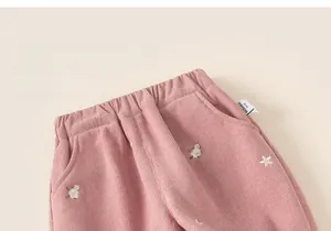 Close-up of girl's pink corduroy pants with elastic waist and small flower embroidery
