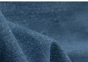Dettaglio della trama in denim blu e della tessitura a saia di qualità sui jeans