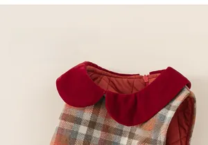 Detail of red velvet Peter Pan collar and quilted lining on plaid girl's dress