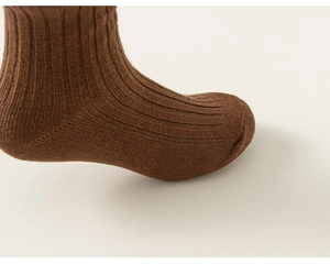 Detail of dark brown ribbed knit cotton knee-high socks for kids with soft texture