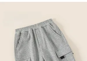 Detail view of boys' grey joggers showing elastic waistband and functional cargo pocket