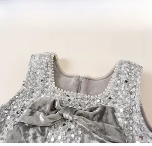 Detail of sequined kids dress with velvet bow and pearl-trimmed square neckline